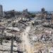 A man pushes a bycicle along as he walks amid building rubble in the devastated area around Gaza's Al-Shifa hospital on April 3, 2024, amid the ongoing conflict between Israel and the Palestinian Hamas militant group. (Photo by AFP)